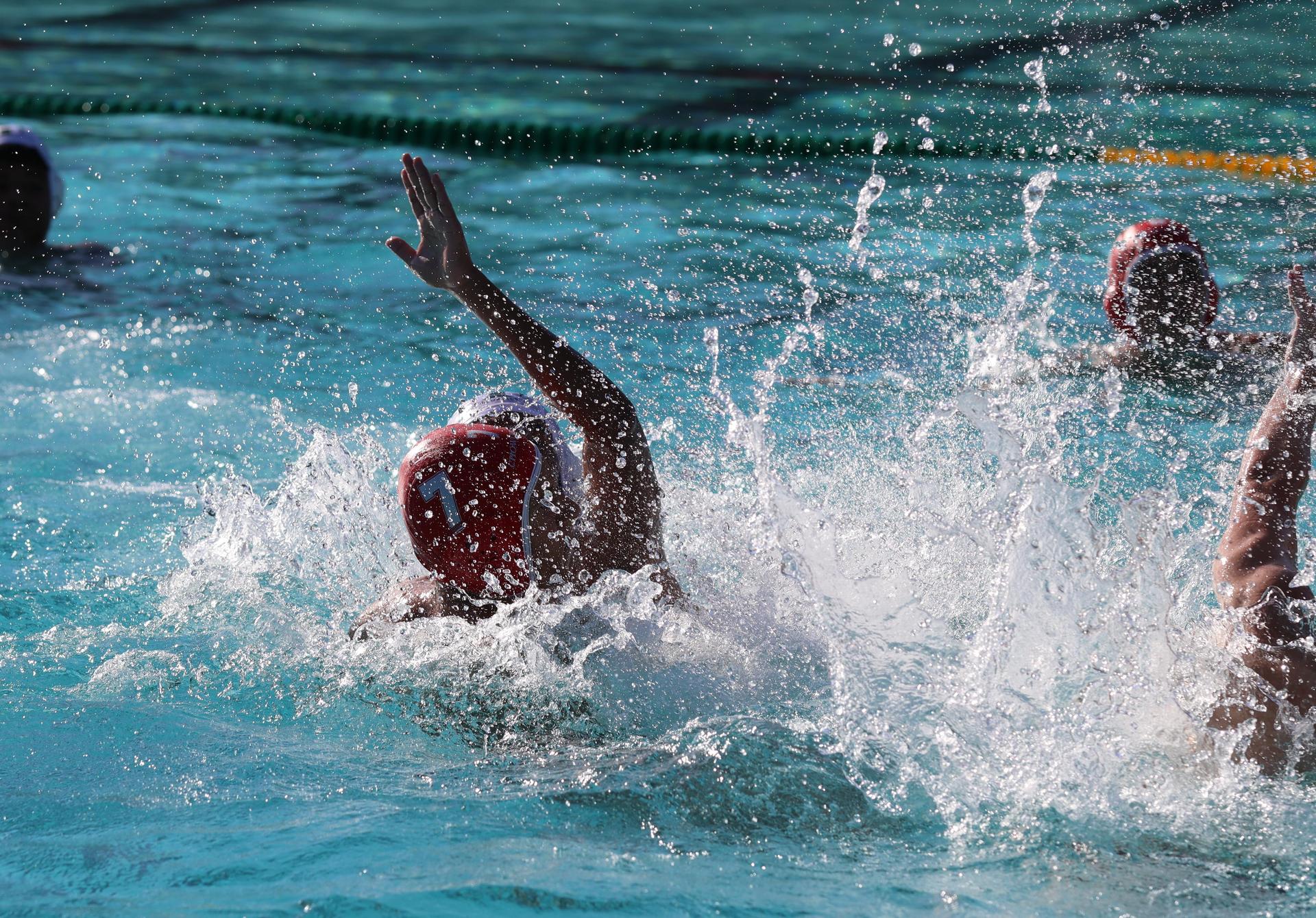 boys water polo players in action against hoover