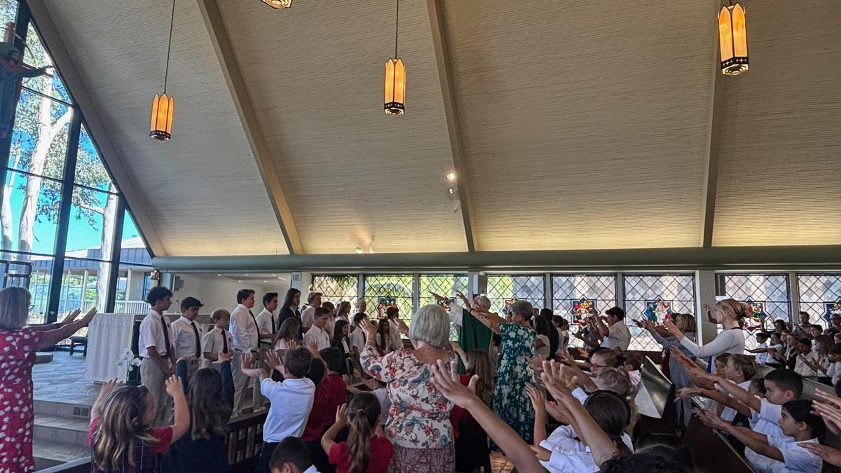School community raises hands in blessing of the Student Council.