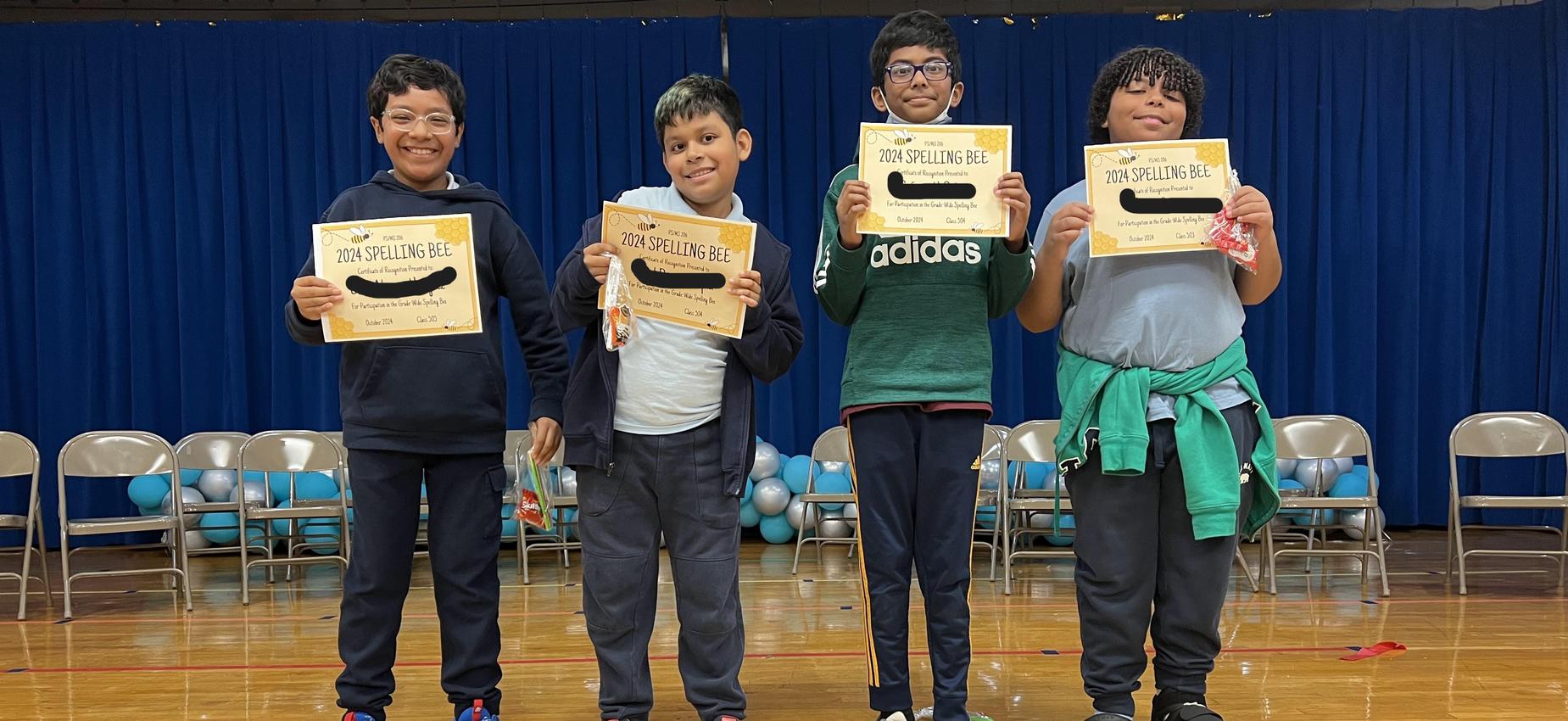 Four boys displaying their Spelling Bee certificates