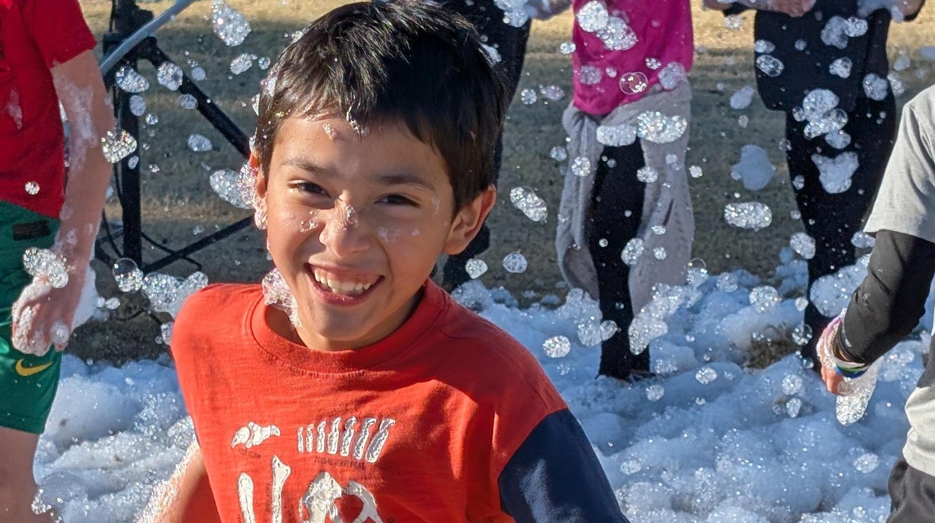 Seminole Primary student smiling running through foam