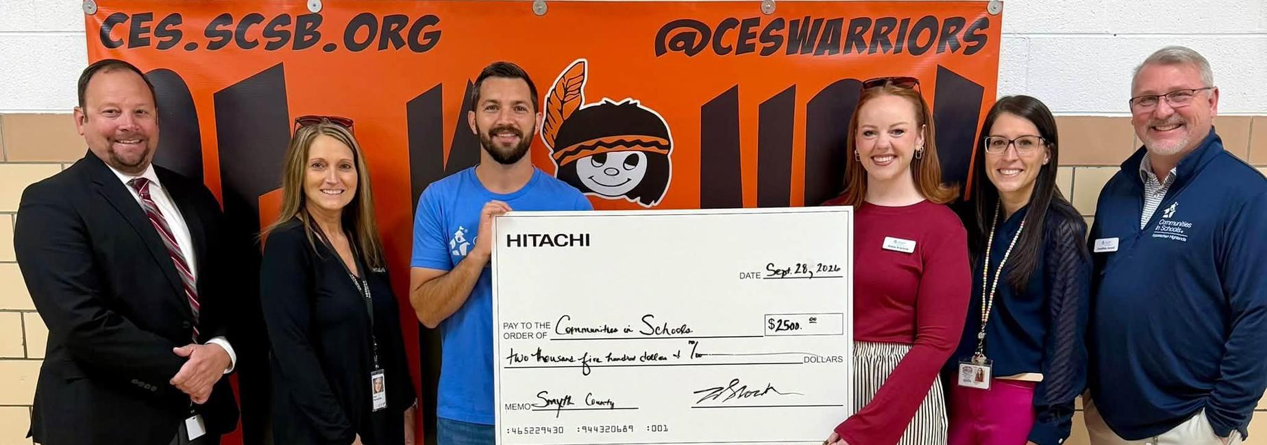 Hitachi and school personnel with check donated to Communities in Schools