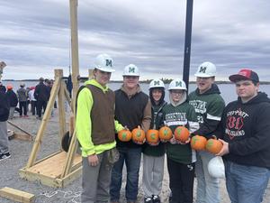 Students hold up pumpkins that spell out "Rockets."