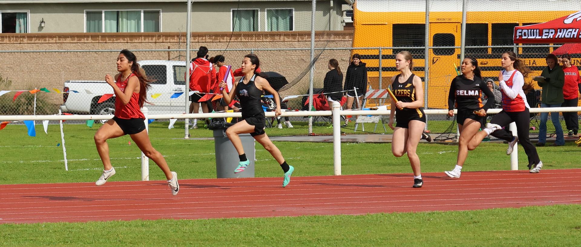 girls running the four by 100 meter relay