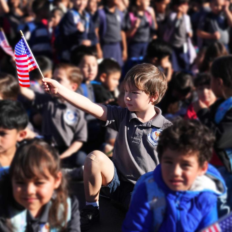 Boy in a crowd holding a flag