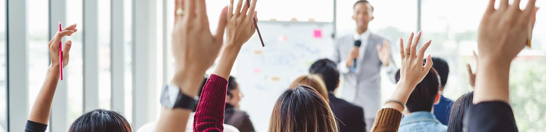 people raising their hands at a presentation