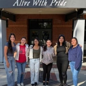 Six Hart High Students pose under a banner with text, "Alive with Pride"