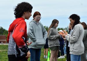 Kids interacting and discussing activities on a school field.