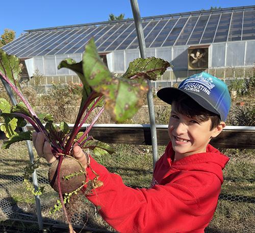 James River 4th grader showing off a beet he harvested at Lynchburg Grows.