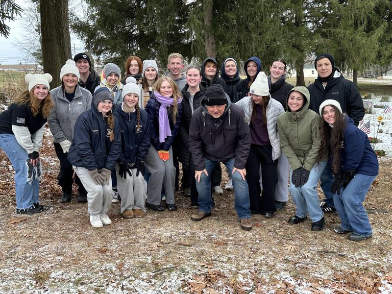 high school students gathered in group outside wearing hats and gloves