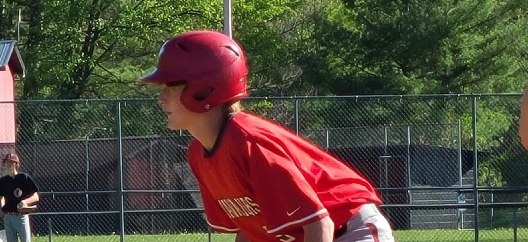 A baseball player waits on base.