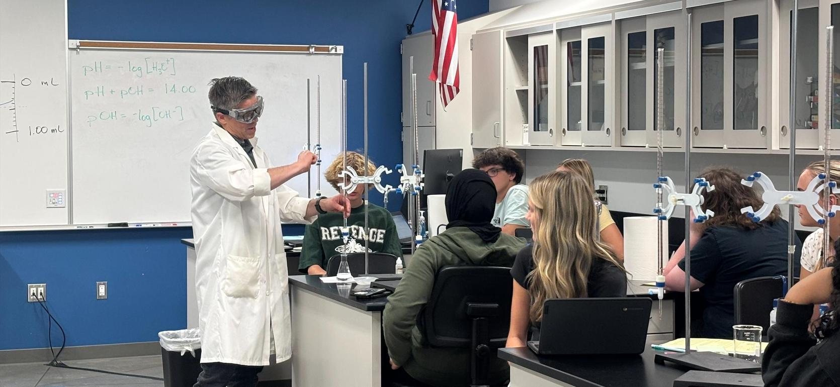 A teacher demonstrating a science experiment to students in a classroom.