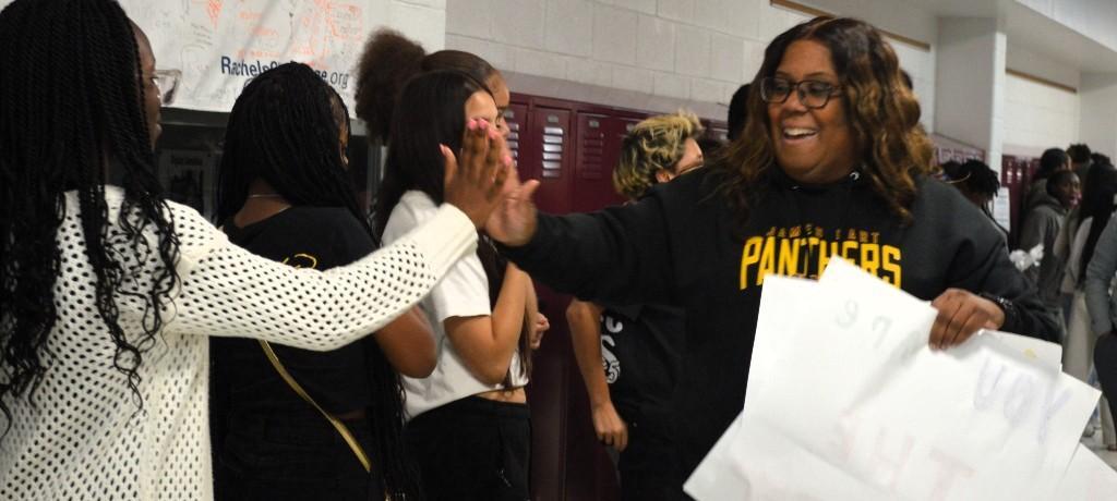 student high-fives principal in hallway