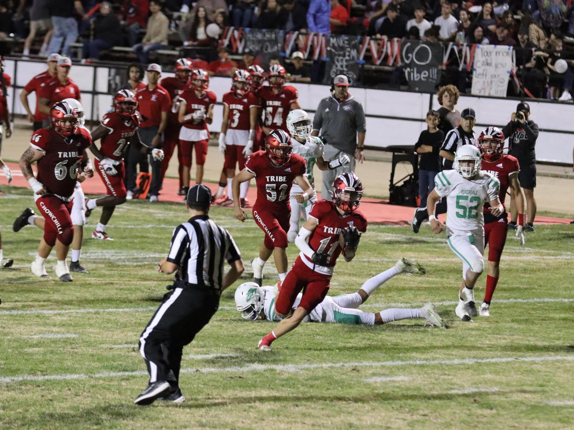varsity football players in action against Riverdale