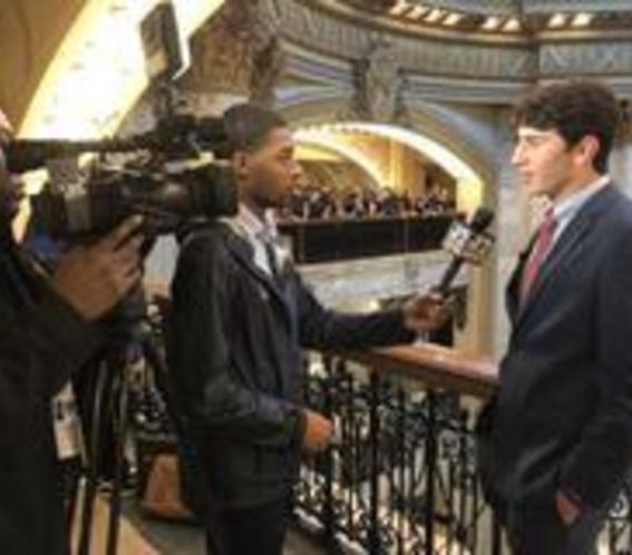 High school boy being interviewed by television news crew