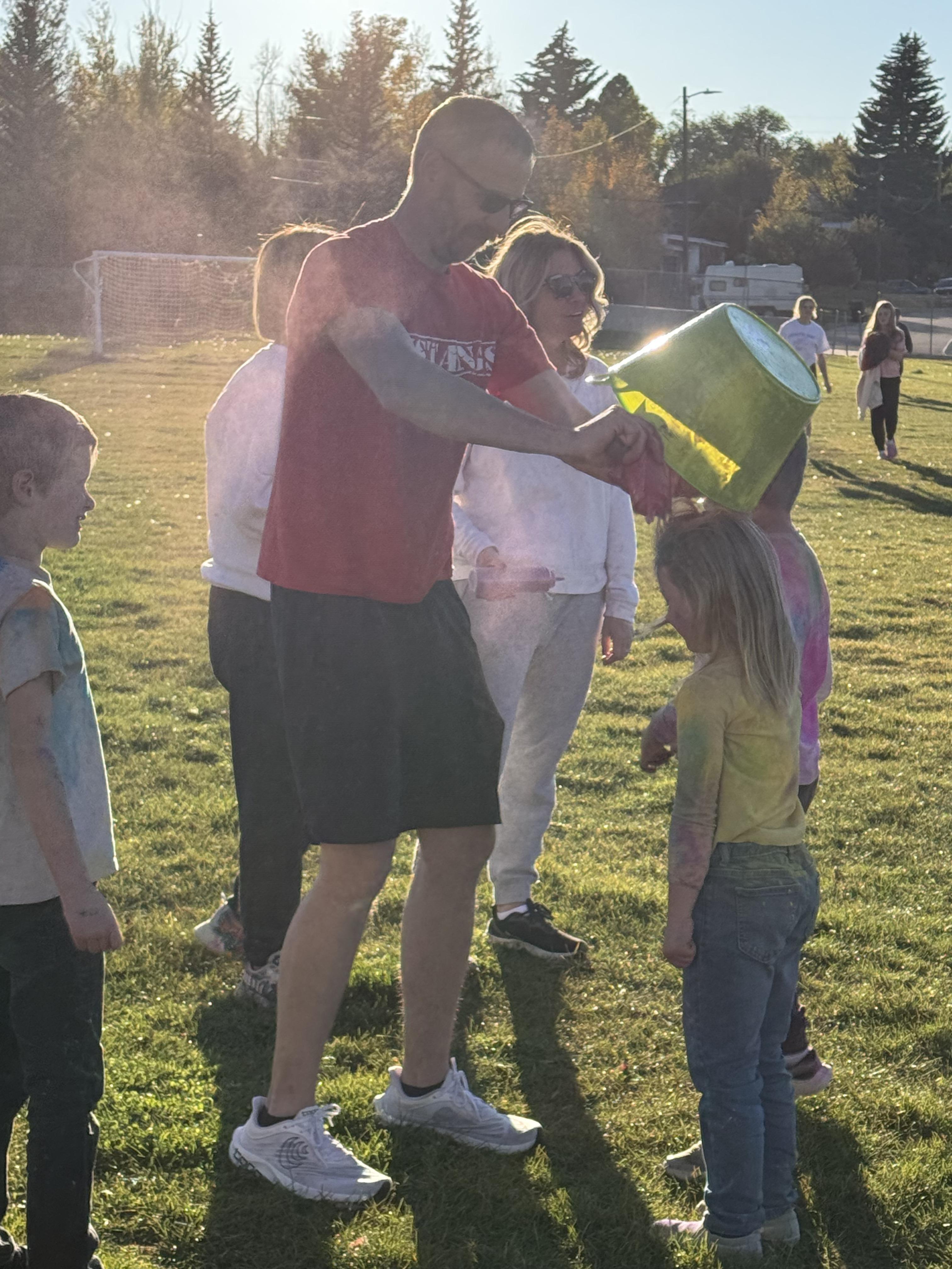 Dumping chalk on a student during the color run