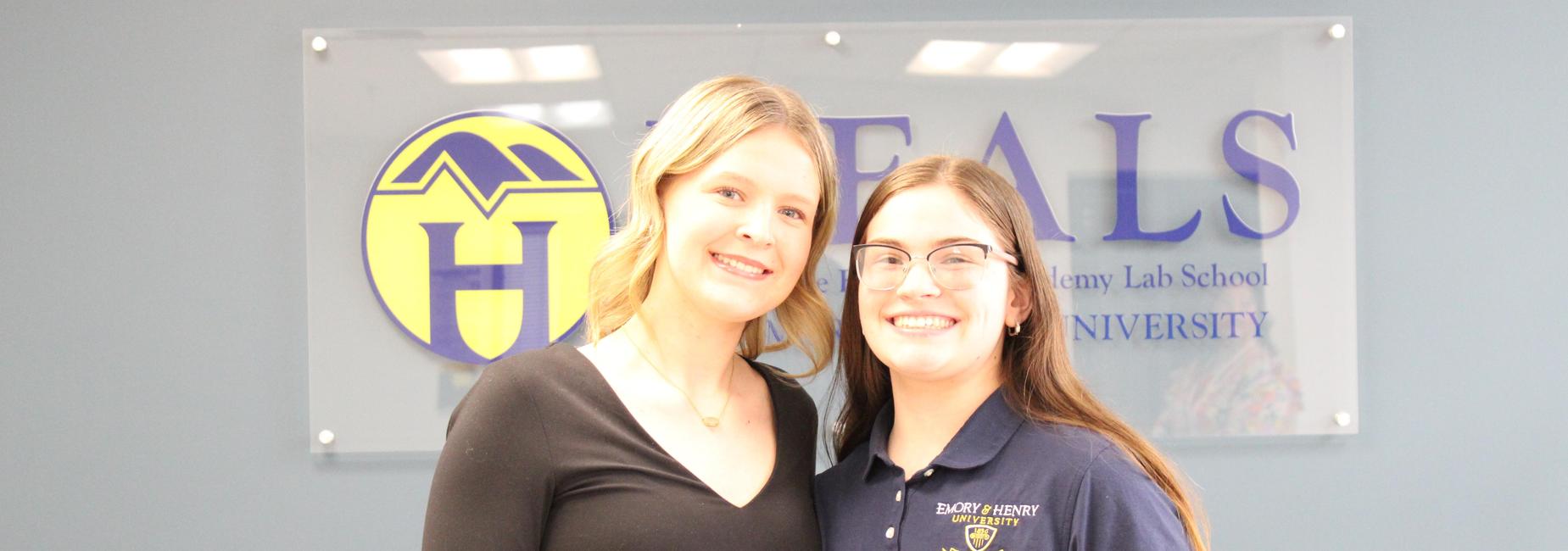 two students posing in front of lab school sign