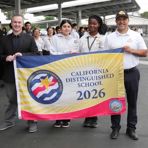 People holding Distinguished School banner