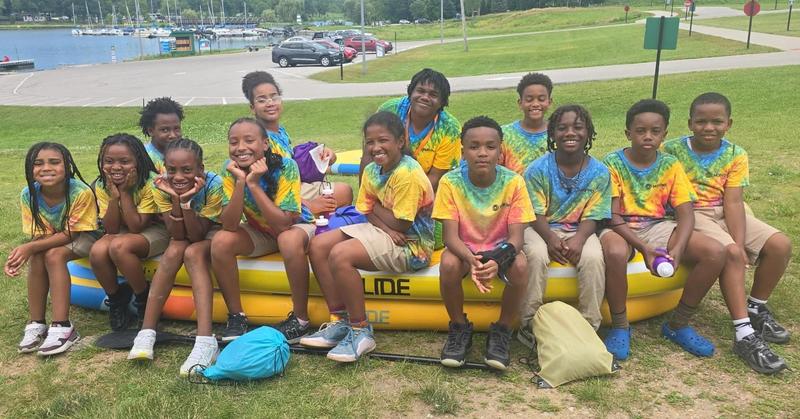 Scholars sitting on a paddleboard