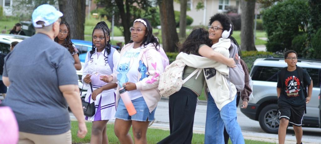 Two students hug.