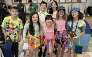 A team of elementary students posing in costume A team of elementary students in red headbands posing with certificates at the Odyssey of the Mind competition.