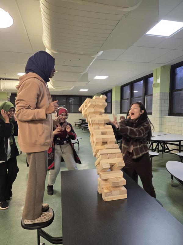 two students playing very large jenga