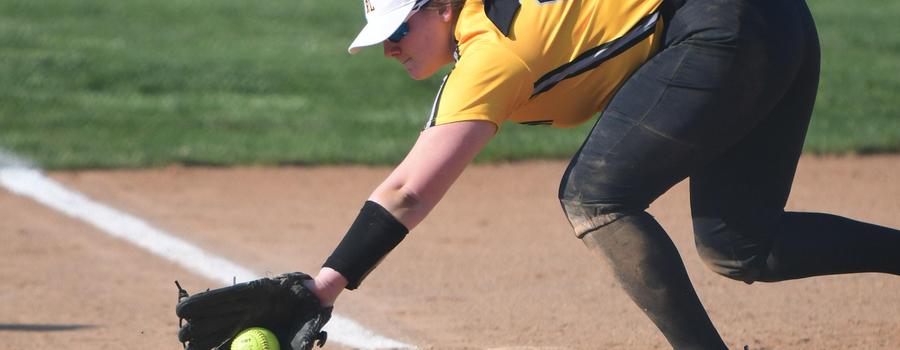 Girls varsity softball player reaching for a ball