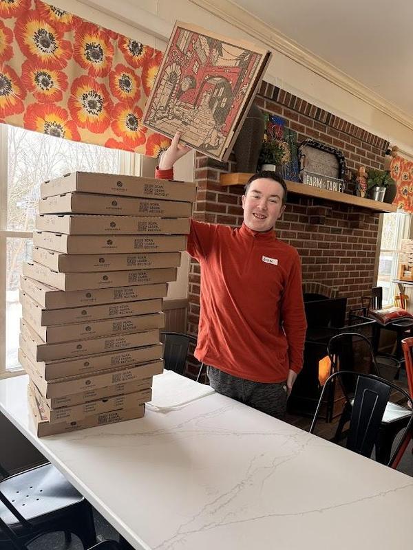 PEP student with a stack of pizza boxes he put together