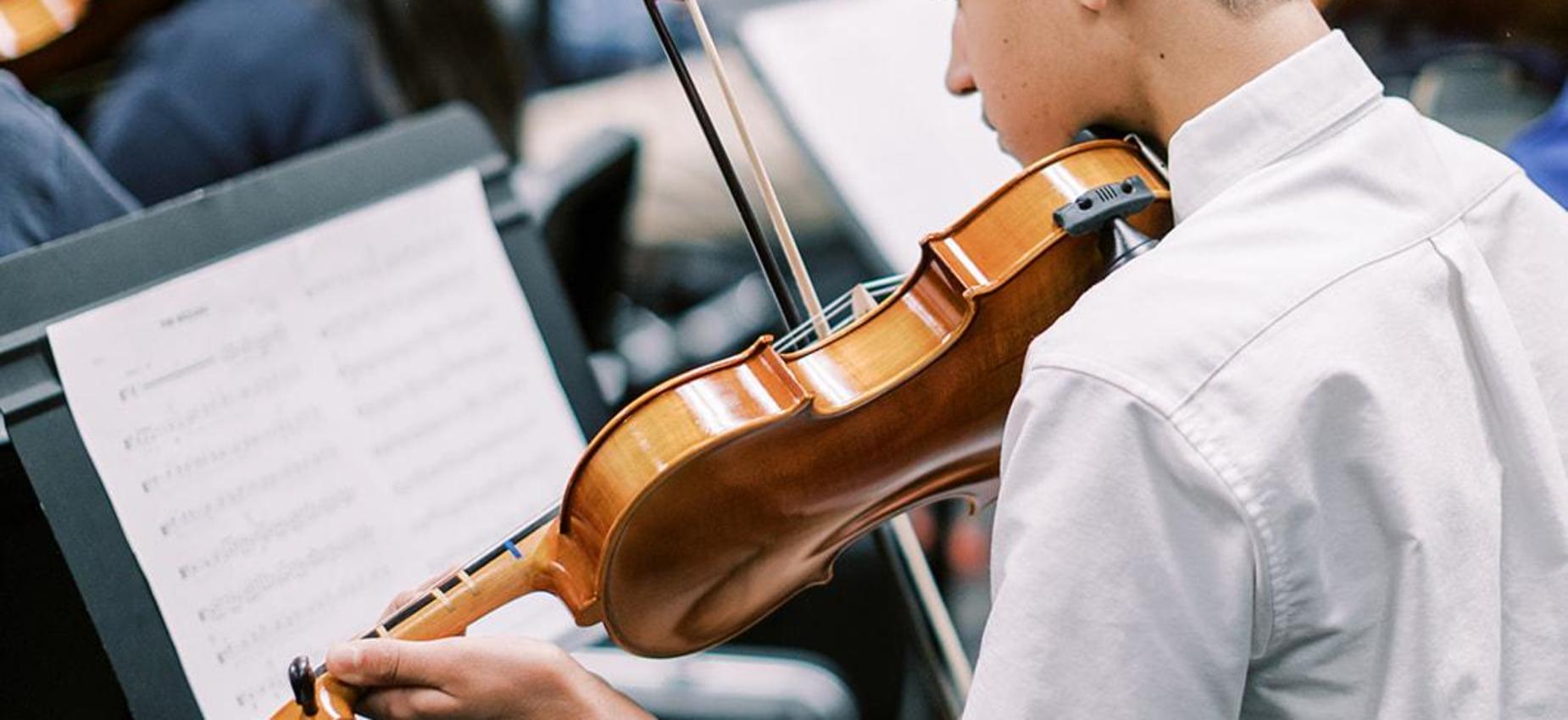 Student plays violin during orchestra class