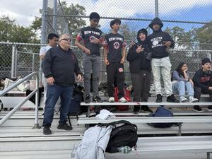 students standing on the bleachers with mr meglio to the left