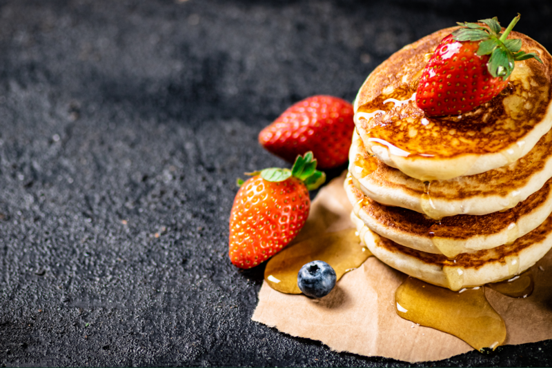 A stack of pancakes with assorted fruit