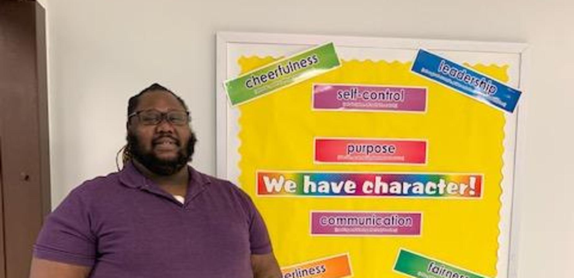 Mr. Martin standing before the character board