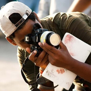 A student taking photographs with a long lens camera.
