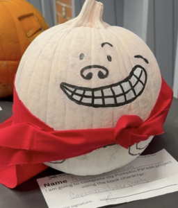a pale white pumpkin with cape and story from student