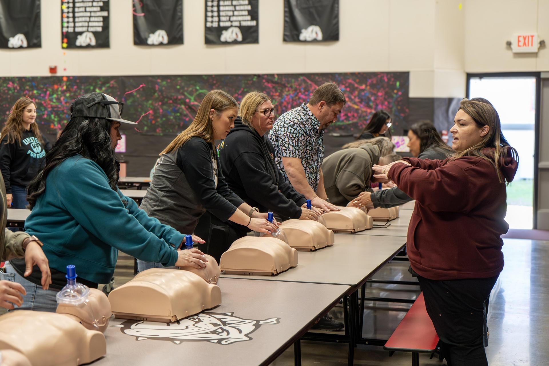 Staff practicing CPR on training mannequins.