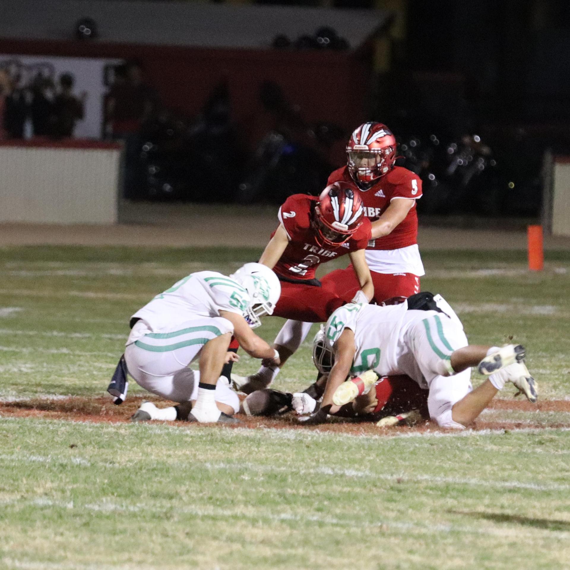 varsity football players in action against Riverdale