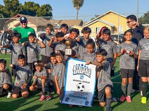 4th - 5th Grade soccer team poses for photo with championship banner