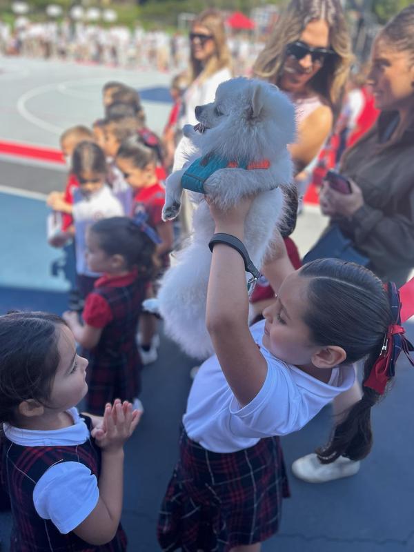Student holds up puppy for blessing of the animals