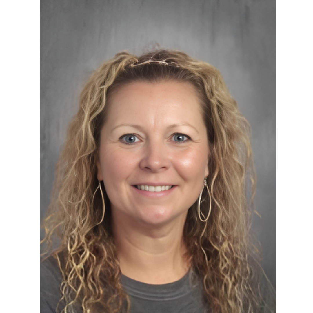 A person with curly hair smiling for the camera