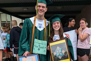 Aaron Burdell and Annabelle Aquino hold their elementary artwork while visiting Harrison Park for their walk through celebration
