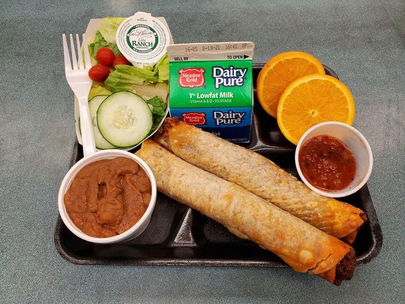 Picture of student lunch tray featuring crispitos, beans, salsa, salad, fruit and milk.