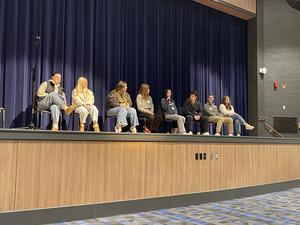 recent high school graduates seated on stage with microphone