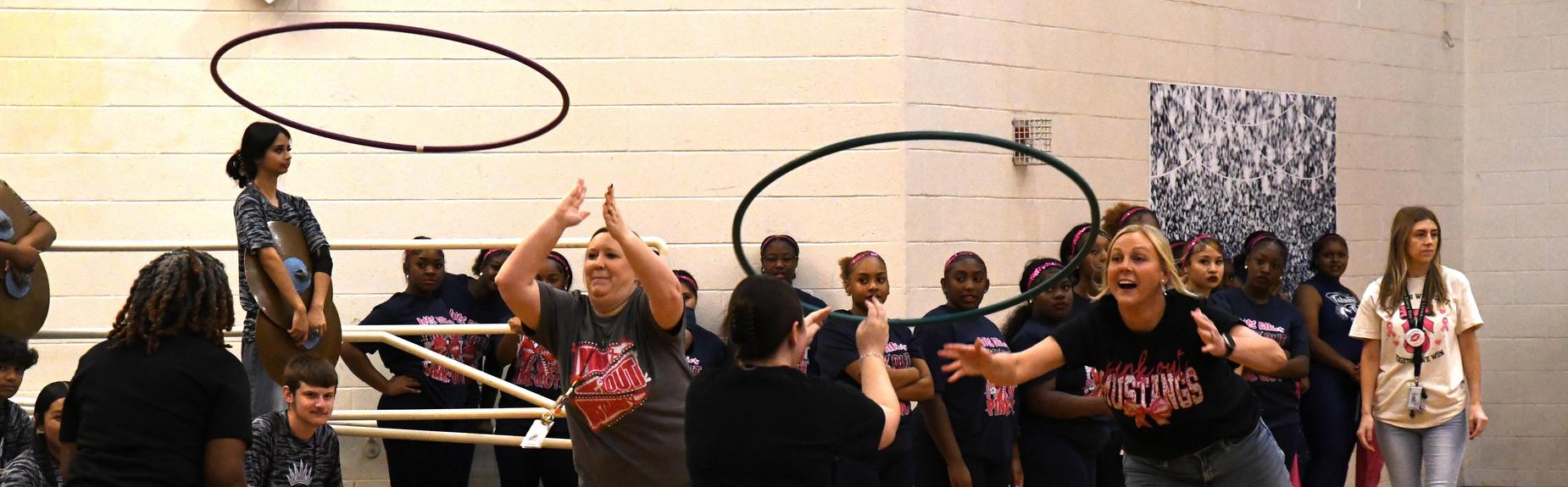 Performers interact with each other while engaged in a fun activity in a gym setting.