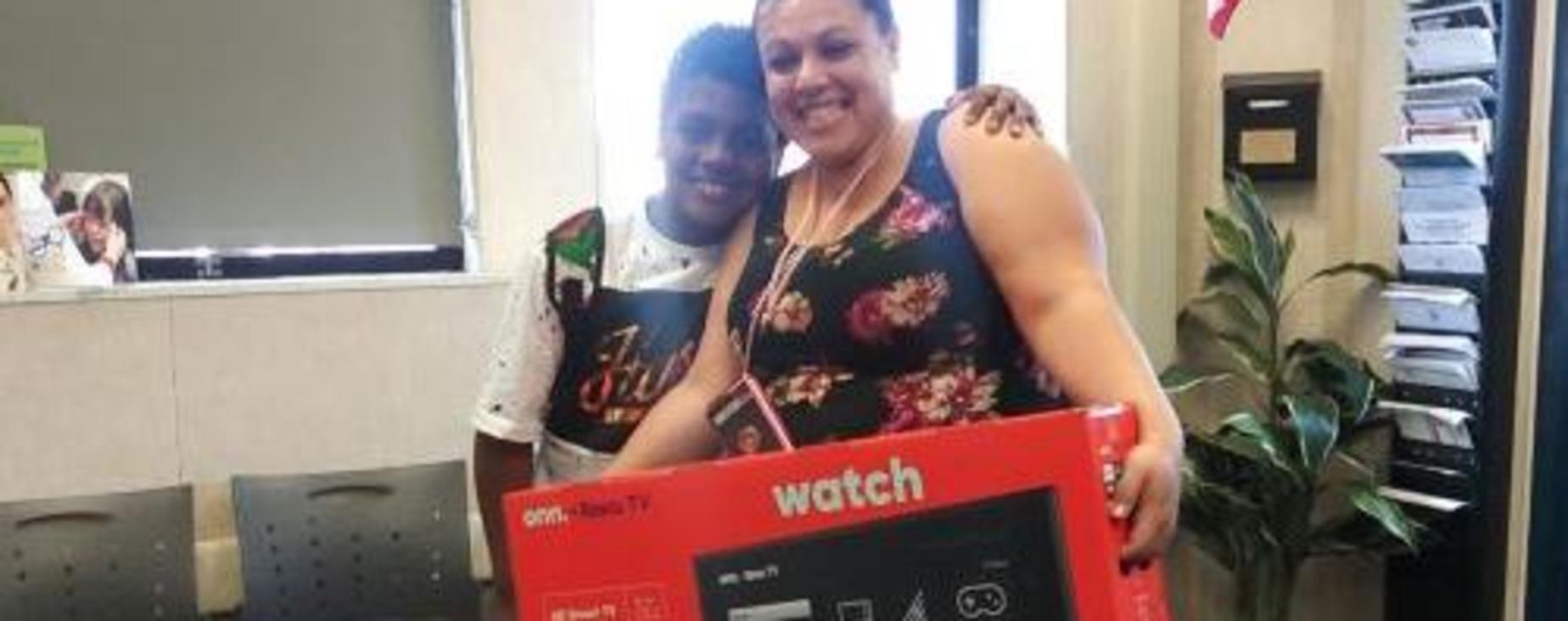 student and mom happily posing with his new tv.