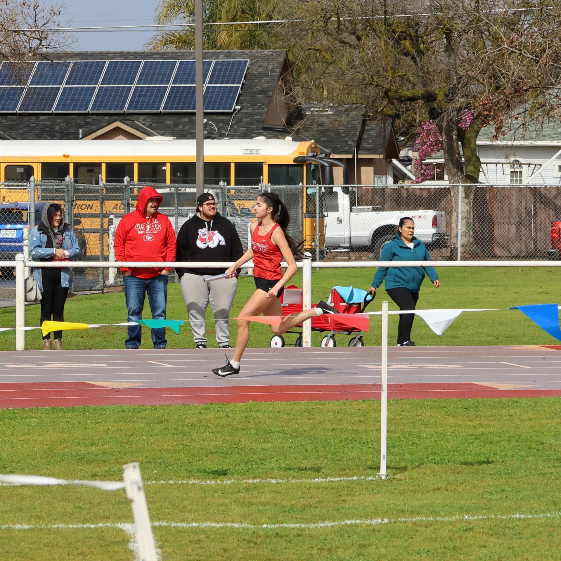 girls running the four by 100 meter relay