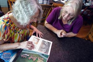 Linda (Ott) Printy and a fellow Cougar Kitten remenisce on their dancing days while looking through old yearbook photos.