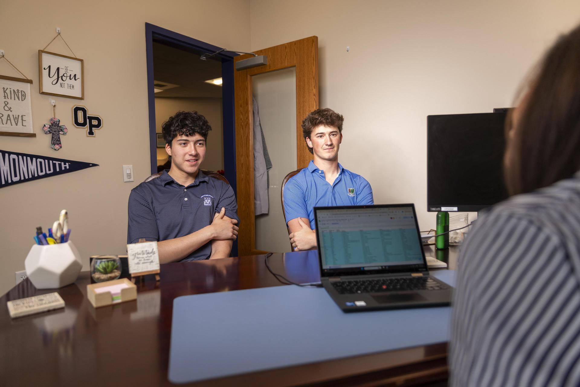 College counselor reviewing college guides with three smiling students