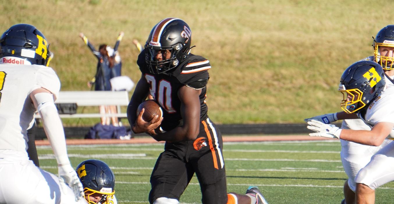 A TKHS varsity football player runs through defenders.