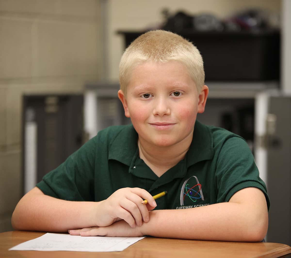 Student working on a notebook in a classroom.