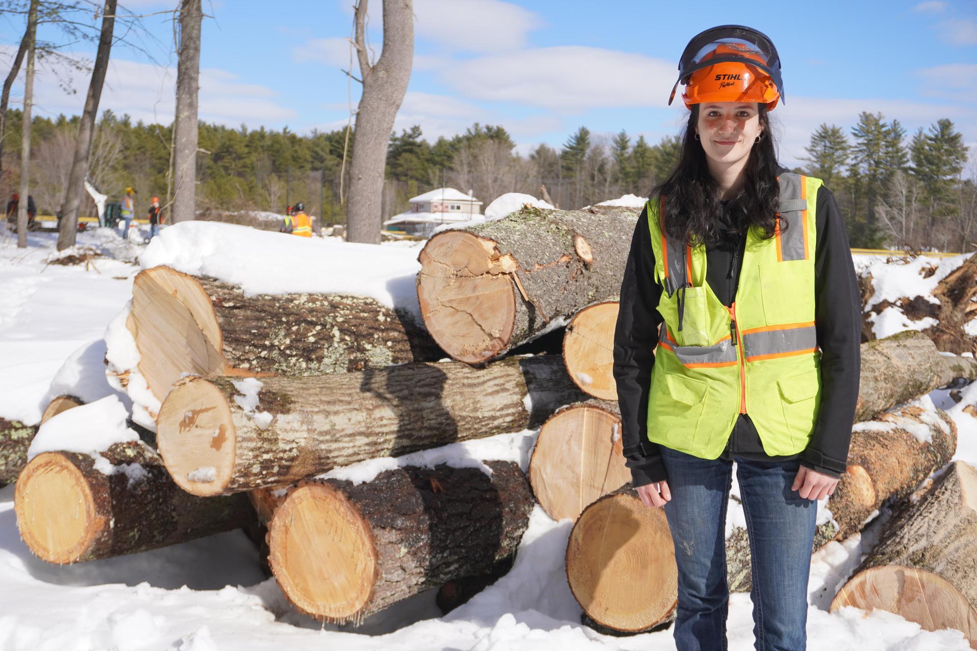 conservation student Melanie Fisher in front of logs
