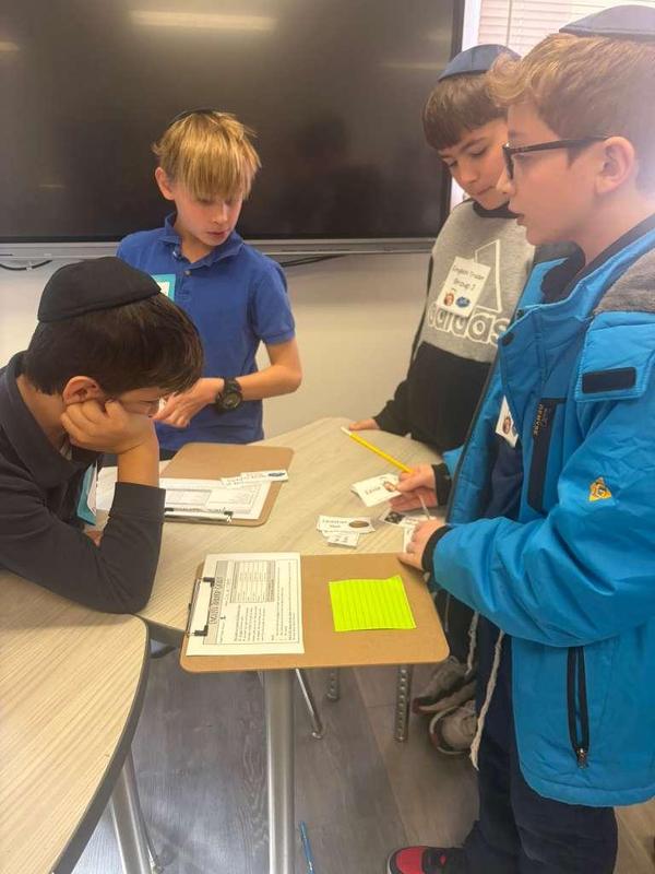 Fifth grade boys practice bartering skills.